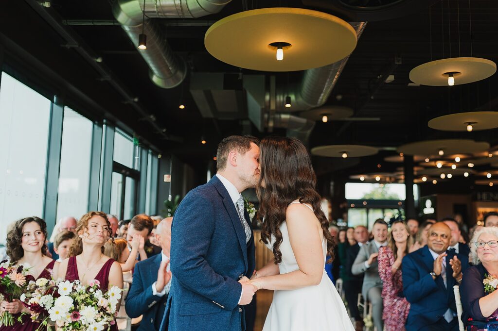 Bride and Groom kissing as they are now Husband and Wife as the crowd applaud // Charlotte Giddings Photography