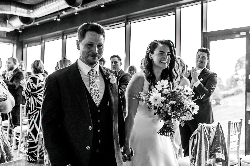 Bride and Groom over the moon as they walk down the aisle at Hencote Estate, Shrewsbury