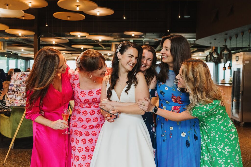 Bride with her girlfriends giggling while waiting for a group photo // Wedding Photographer Shropshire