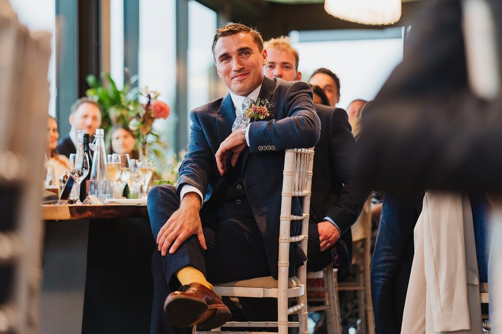 Best man listening to the groom talk in his speech looking very proud and delighted to be the best man // Charlotte Giddings Photography