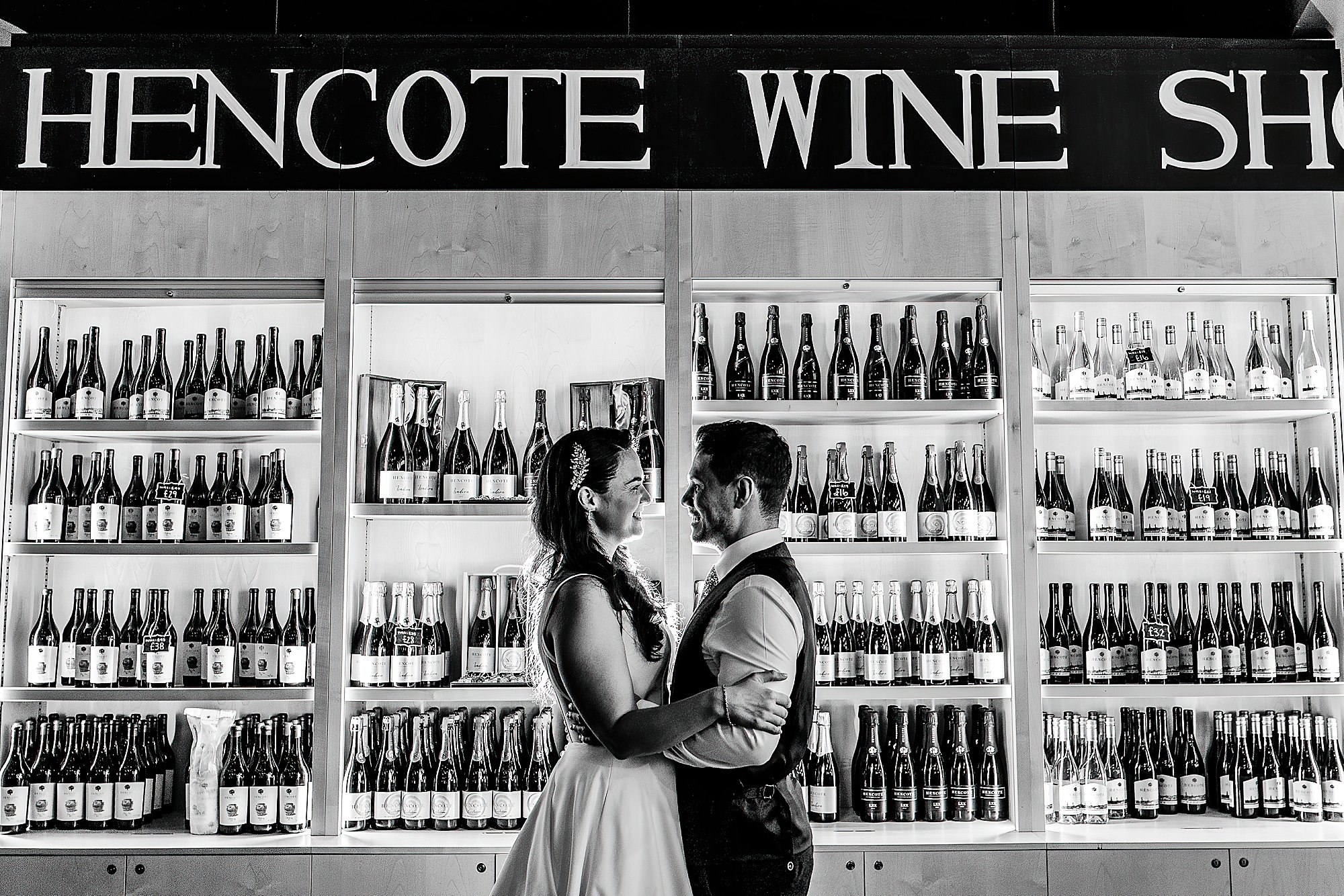 Hencote Wedding Photographer00095 Bride and groom giggling between themselves infront the wine stock at Hencote Estate, Shrewsbury