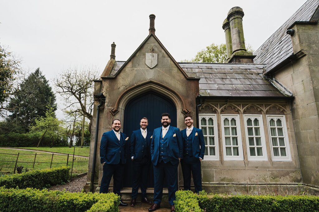 Formal portrait of groom and groomsmen outside the Stone Lodge, Shropshire Wedding Venue, Combermere Abbey