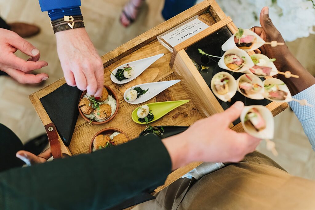People reaching for canapes in the Pavilion at Combermere Abbey