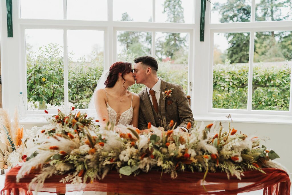 Bride and Groom kissing as they have just signed the document in the Glasshouse after their ceremony // Charlotte Giddings Photography