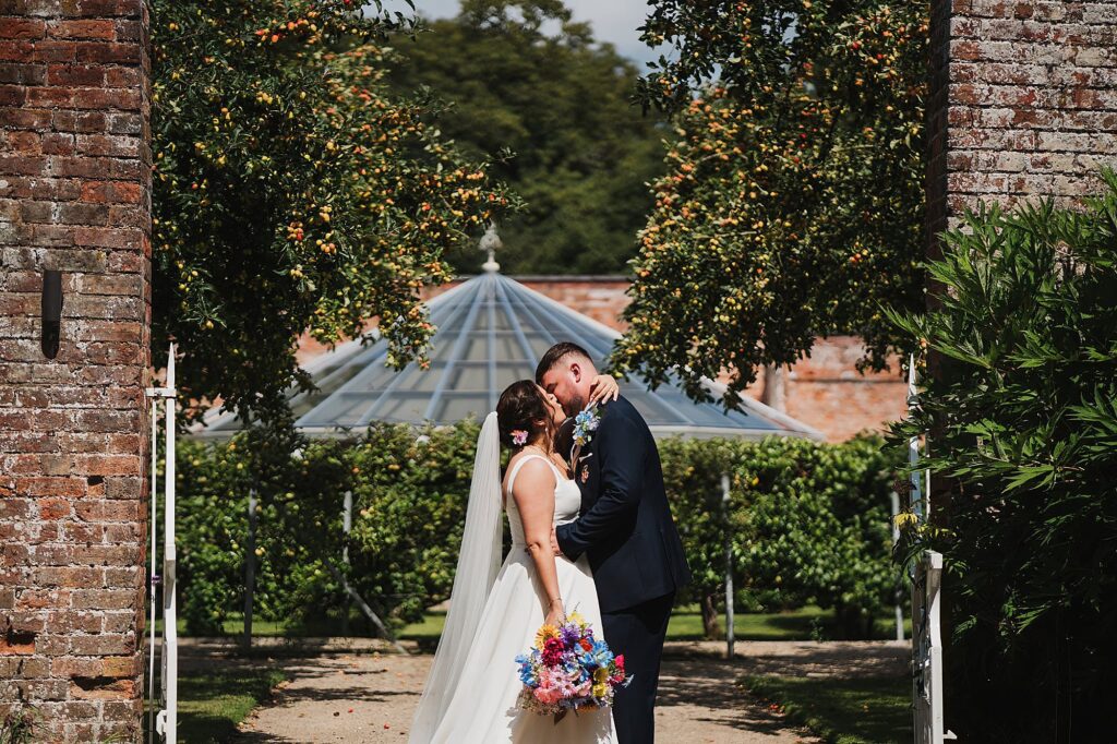 Bride and Groom kissing in the walled gardens at Combermere Abbey // Shropshire Wedding Photographer