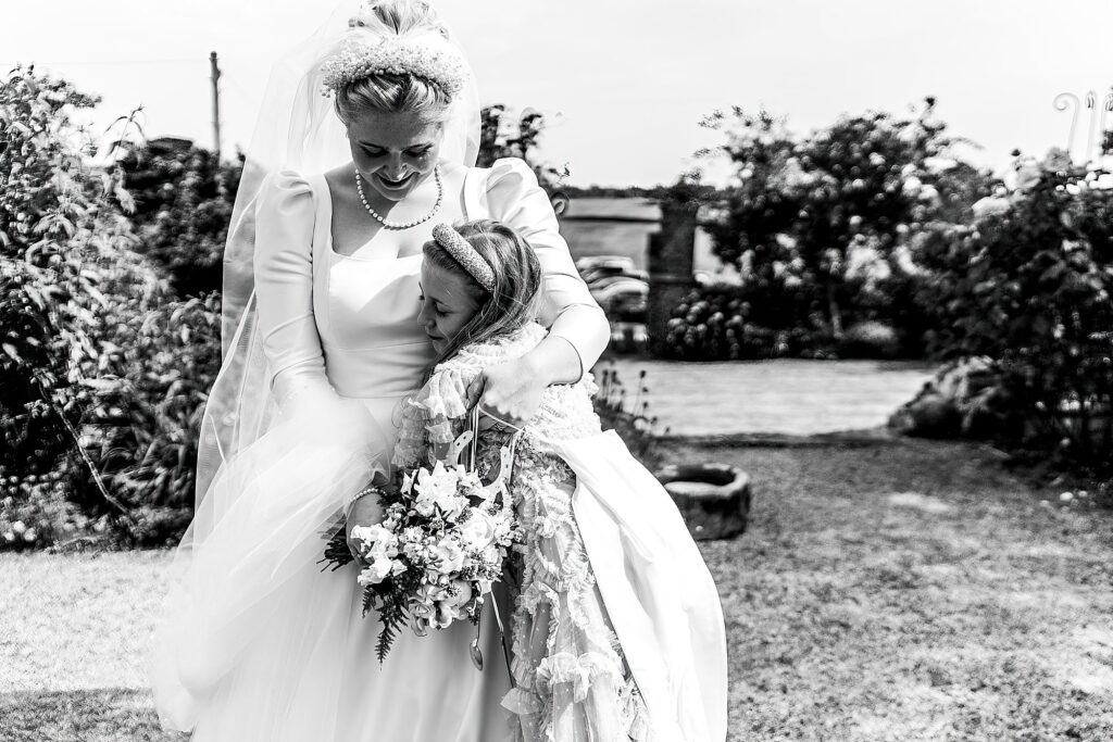 Flower Girl giving the Bride and cuddle at Shropshire Marquee weddding