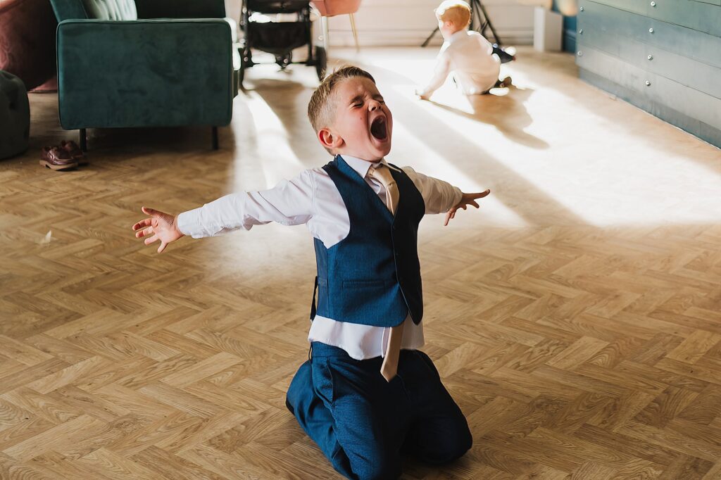 Young boy slipping, sliding and singing at Combermere Abbey // Wedding Photographer Cheshire