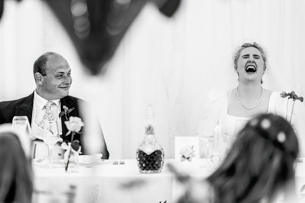 Bride belling laughing at the Best Man's speech at marquee wedding in Shropshire // Shropshire Wedding Photographer