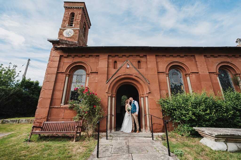 Bride and Groom kissing in the church door way at Grinshill Church //.Shropshire Wedding Photographer