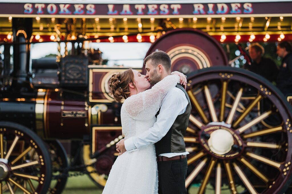 Bride and Groom kissing in the grounds of the Moat Shed, Shropshire by the steam engines