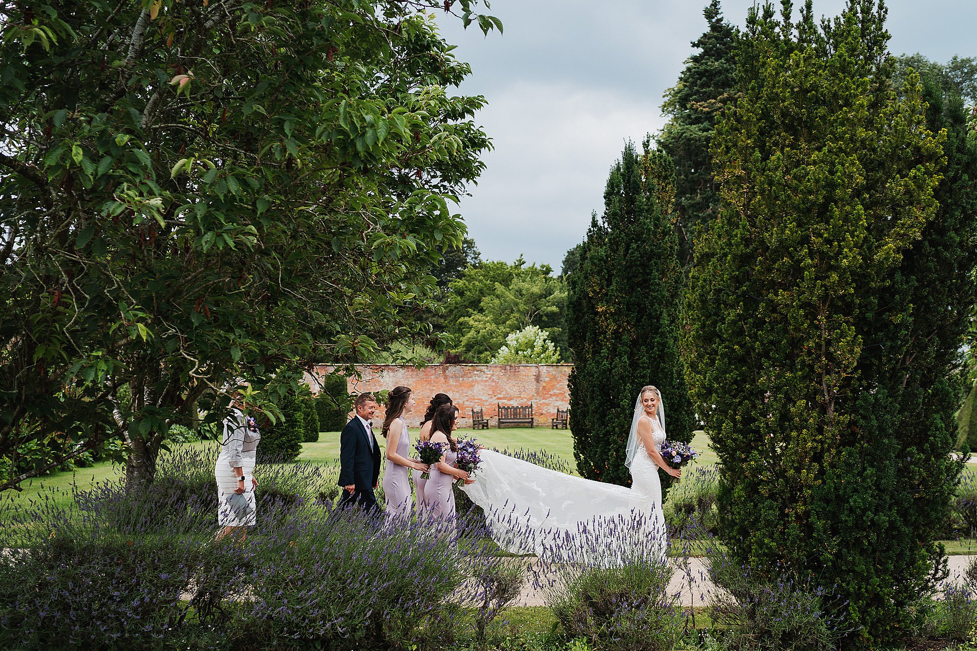 Bride walking up the glasshouse with bridesmaids at Cheshire wedding venue combermere Abbey